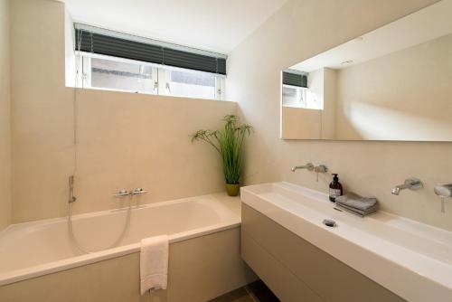 a bathroom with a tub and a sink and a mirror at Hestia (8p) in Nes