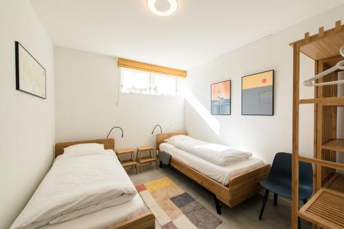 two beds in a small room with a ladder at Hestia (8p) in Nes