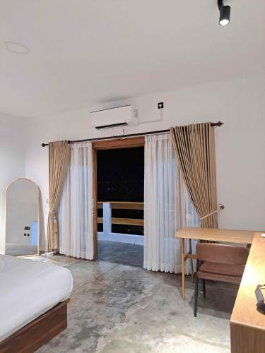 a bedroom with a bed and a desk and a window at Second Point View BK in Batukaras