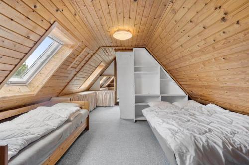 a bedroom with two beds in a wooden house at S705-Stroby-Hybenvej-1 in Strøby
