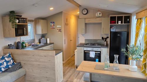 a kitchen and living room with a stove and refrigerator at The Bouys & Gulls Retreat in Parkeston