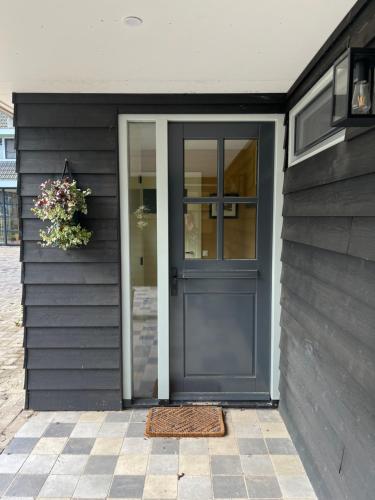 a grey door on a house with a window at In de Hemmele bij Maria in Lievelde
