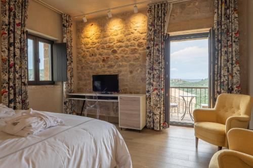 a bedroom with a bed and a television and a balcony at Alistos Hotel in Gythio