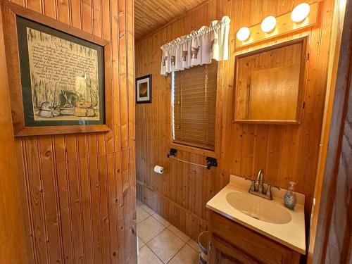 a wooden bathroom with a sink and a mirror at Pinewood - Bouchard Shores Resort in Minocqua