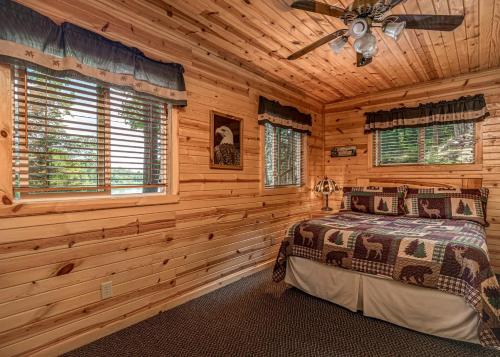 a bedroom with a bed in a log cabin at Pinewood - Bouchard Shores Resort in Minocqua