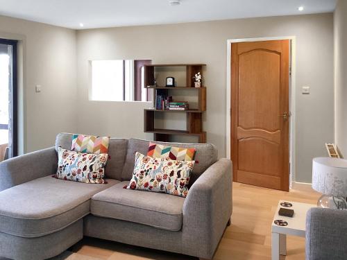 a living room with a gray couch with pillows at Stroma in Edderton