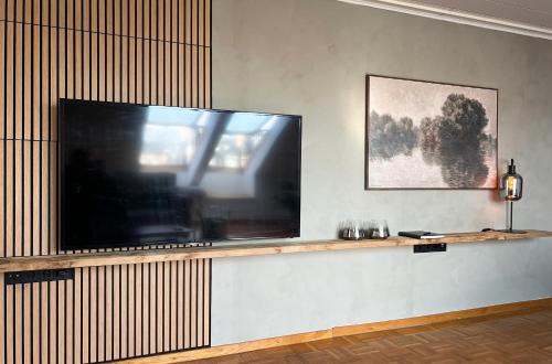 a large flat screen tv on a wall at De Bookholt - Premium Ferienwohnung in Vreden
