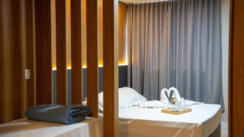 a hotel room with two beds and a window at Eleganz Suítes Exclusive Centro in Gramado