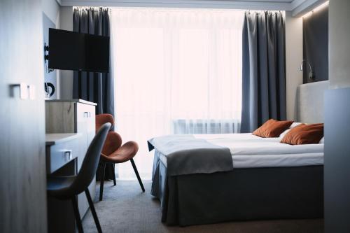a hotel room with a bed and a window at Hotel Cristal Park in Tarnów