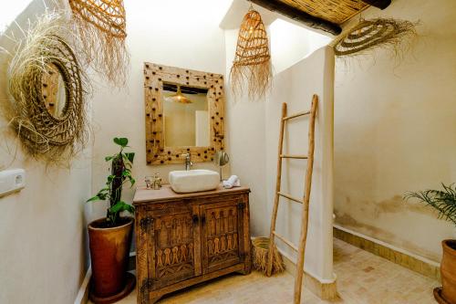 a bathroom with a sink and a mirror at Riad Taww'Ami in Marrakesh