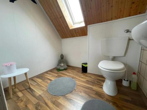 a bathroom with a toilet and a wooden ceiling at Ferienhaus Leuchtturm in Dornum