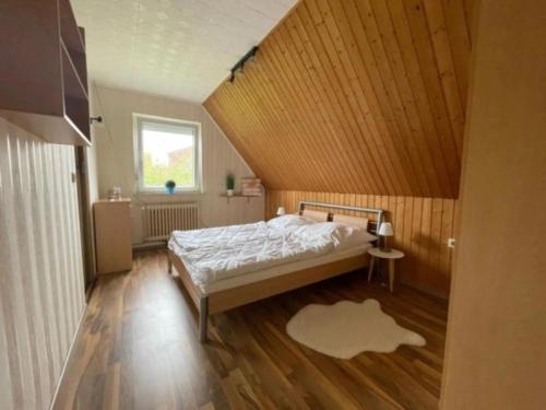 a bedroom with a bed with a wooden ceiling at Ferienhaus Leuchtturm in Dornum