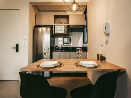 a kitchen with a wooden table with two glasses of wine at Xtay Vila Madalena - Stay close to everything with an outdoor pool and access to the best coworking spaces in Vila Madalena in São Paulo
