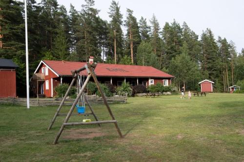 eine Schaukel im Garten vor einem Haus in der Unterkunft Kloster Gård - Cabins & apartments near Astrid Lindgrens World in Hultsfred