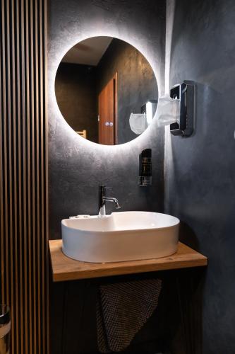 ein Badezimmer mit einem weißen Waschbecken und einem Spiegel in der Unterkunft Hotel Dastan in Levice