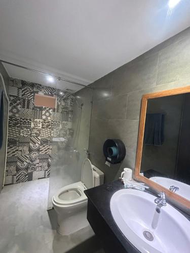 a bathroom with a sink and a toilet and a mirror at Lemon House in Quy Nhon