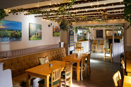 a restaurant with wooden tables and a bar at Redmire Village Pub in Redmire