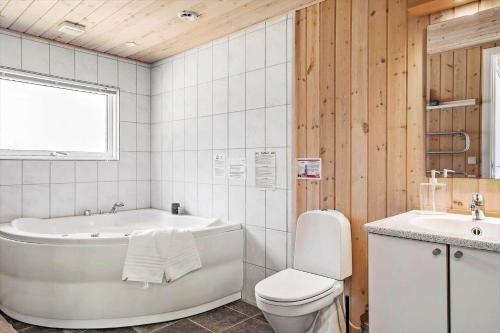 a bathroom with a tub and a toilet and a sink at OH156-Hadsund-Halvrebene-26 in Hadsund