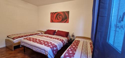 a bedroom with two beds next to a window at I Sei Petali Apartment in Capo di Ponte
