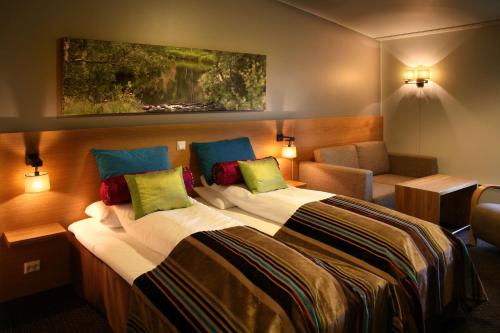 Una habitación de hotel con una cama grande y una silla. en Scandic Stiklestad, en Verdal