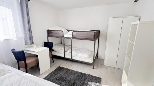 a bedroom with a bunk bed and a table and a bed at Ferienwohnung Melody in Weisweil