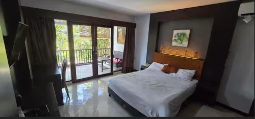 a bedroom with a bed and a balcony at Green Cocoon at Bali beach in Sanur
