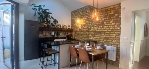 a kitchen with a table and a bar with chairs at Stylish Cottage with Loft Sleeps 4 in Dublin