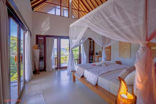 a bedroom with a white bed with a canopy at Villa Sky Dancer - Bali in Amed