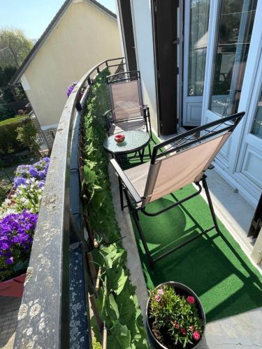 a balcony with a table and chairs and flowers at Appartement 3 pièces in Mareil-Marly