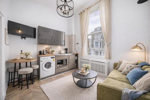 a living room with a couch and a kitchen at The Castletown Collection in London