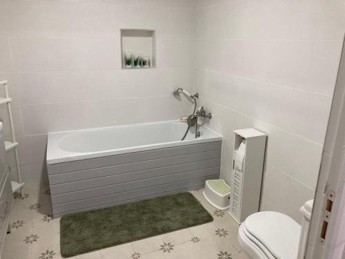 a white bathroom with a tub and a toilet at Casa Borboleta in Chão de Lamas