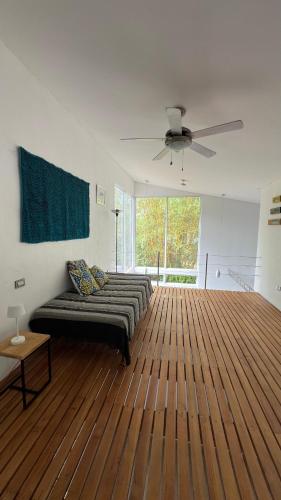 a living room with a couch and a ceiling fan at Villas Isla Escondida in Boca Chica