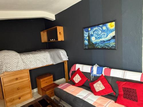 a bedroom with a couch and a bunk bed at Loft zona centro La Merced in San Cristóbal de Las Casas