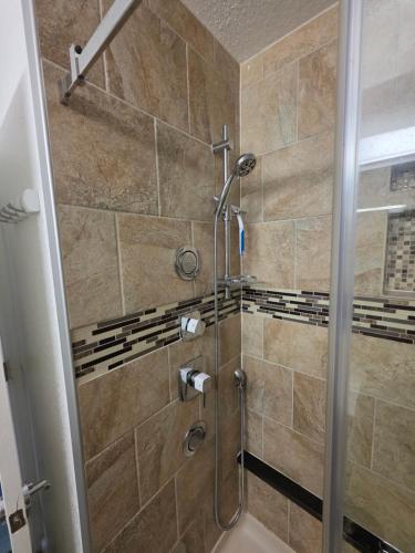 a shower with a glass door in a bathroom at Modern Retro 2BR Condo in High Point