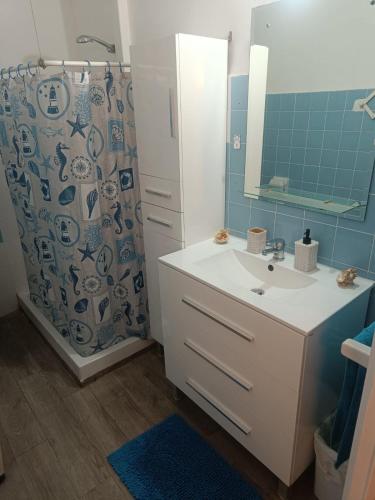 a bathroom with a sink and a shower curtain at Mediterraneo in Vinarós