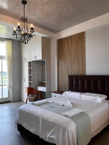 a bedroom with a large bed and a chandelier at Cevero Rodriguez Hotel Boutique in Yurimaguas
