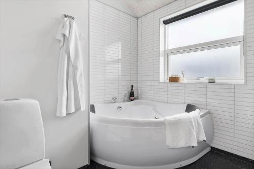 a white bathroom with a tub and a window at OH543-Hadsund-Haslevgarde-eng-16 in Hadsund