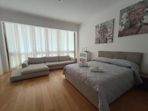 a bedroom with a large bed and a couch at Suite Del Redentore 44 in Caserta