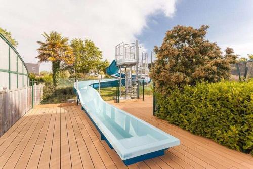 a playground with a slide in a park at Camping Paradis les Capucines in Trédrez
