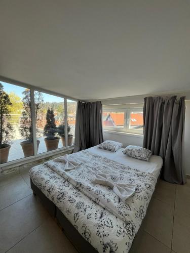 a bedroom with a bed and a large window at GFS way studios - greenline accomodation in Ljubljana