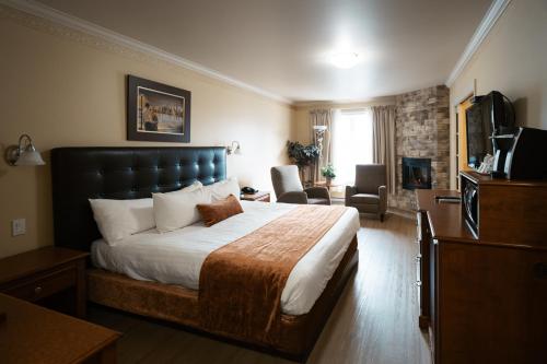 a bedroom with a large bed and a living room at Auberge l'Ambassadeur in Amqui