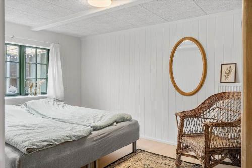 a bedroom with a bed and a mirror and a chair at 722-Thyboron-Vesterhavsgade-144 in Thyborøn