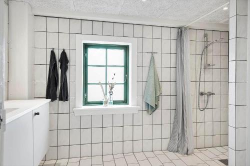 a white tiled bathroom with a window and a shower at 722-Thyboron-Vesterhavsgade-144 in Thyborøn