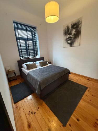 a bedroom with a bed and a large window at Apartamenty Łuczkowskiego z widokiem na Stary Rynek i Studnie 1 102m2 in Chełm