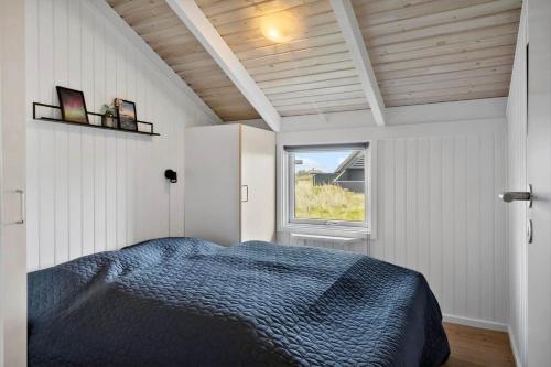 a bedroom with a bed in a room with a window at 313-Harboore-Fourmivej-68 in Harboør