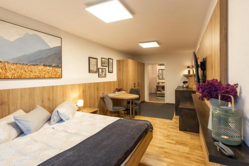 a bedroom with a bed and a desk and a table at Studio Toblaten in Inzing