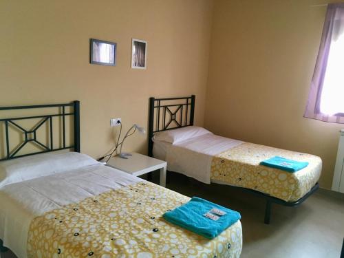 a bedroom with two beds and a window at Albergue Los Templarios in Terradillos de Templarios