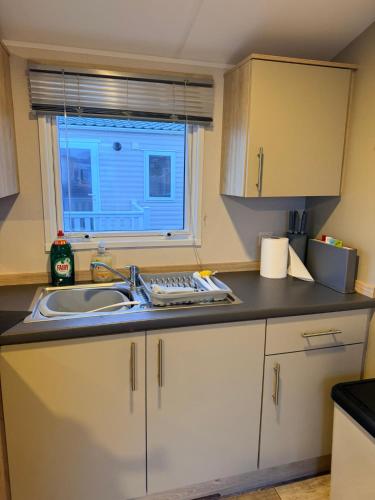 a small kitchen with a sink and a window at The Bouys & Gulls Retreat in Parkeston