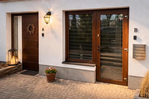 a front door of a house with a potted plant at 3 Rooms Garden Parking in Raszyn
