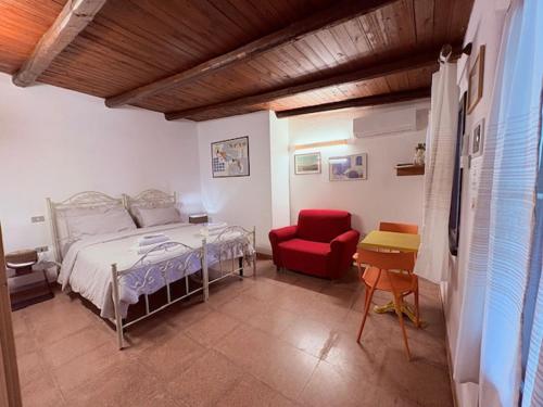 a bedroom with a bed and a red chair at Villa Donna Sibilla in Merine